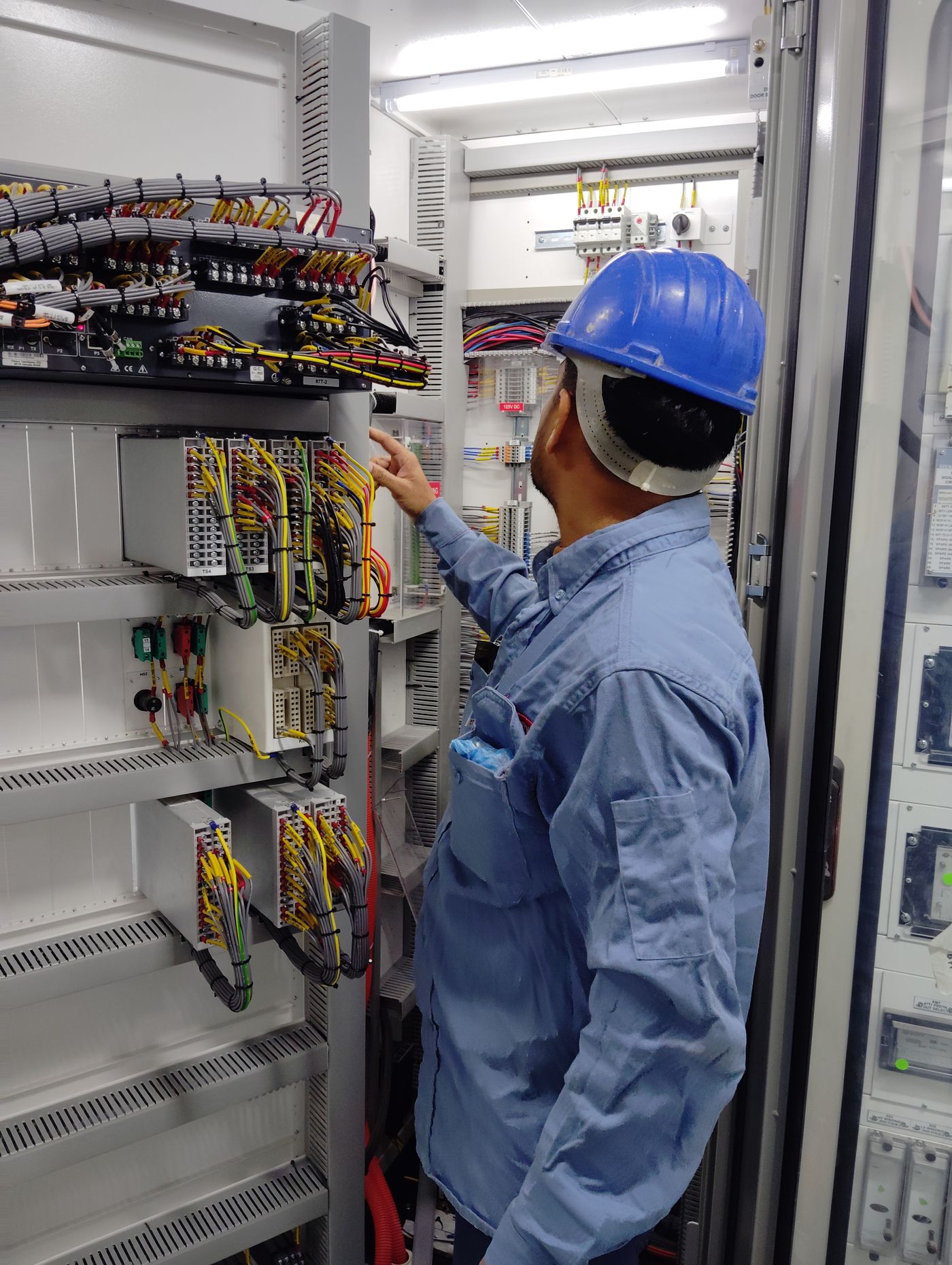 Electrician testing wiring in an industrial control panel